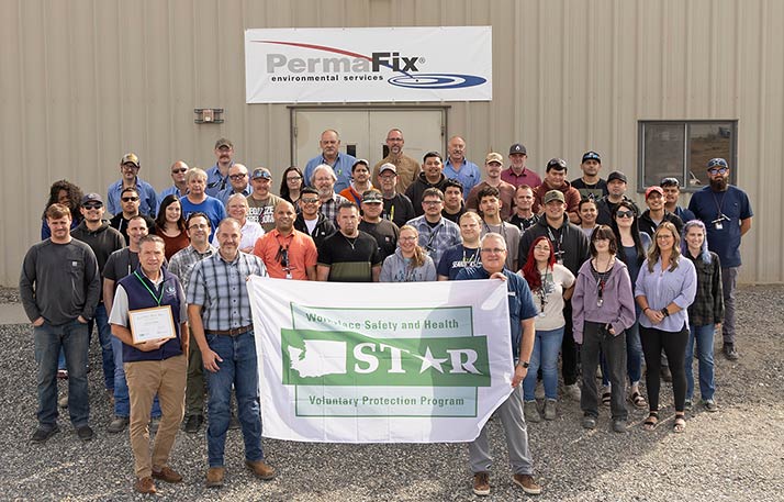 Group photo of PermaFix employees holding the STAR flag.