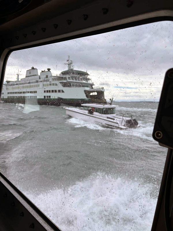 U.S. Coast Guard photo shows the ferry Samish coming to the aid of a cabin cruiser that had been hit by high winds and waves. Ferry crewmembers are receiving the Governor’s Lifesaving Award for rescuing the passengers and their dogs from the damaged boat.