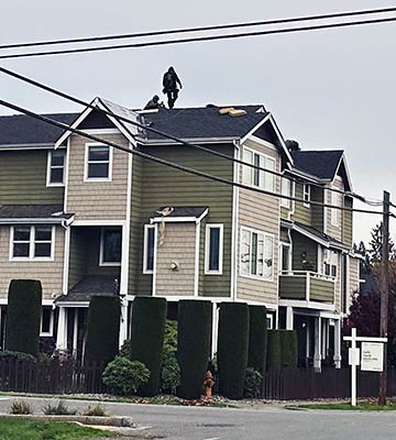 L&I photo shows Allways Roofing workers re-roofing a three-story building in Snohomish with no fall protection system in place.