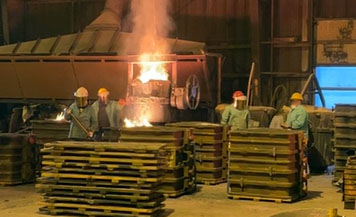 Photo shows Young Corporation employee on the far right working around molten metal during pouring operations without appropriate face protection. All other employees were wearing face shields during the pour.